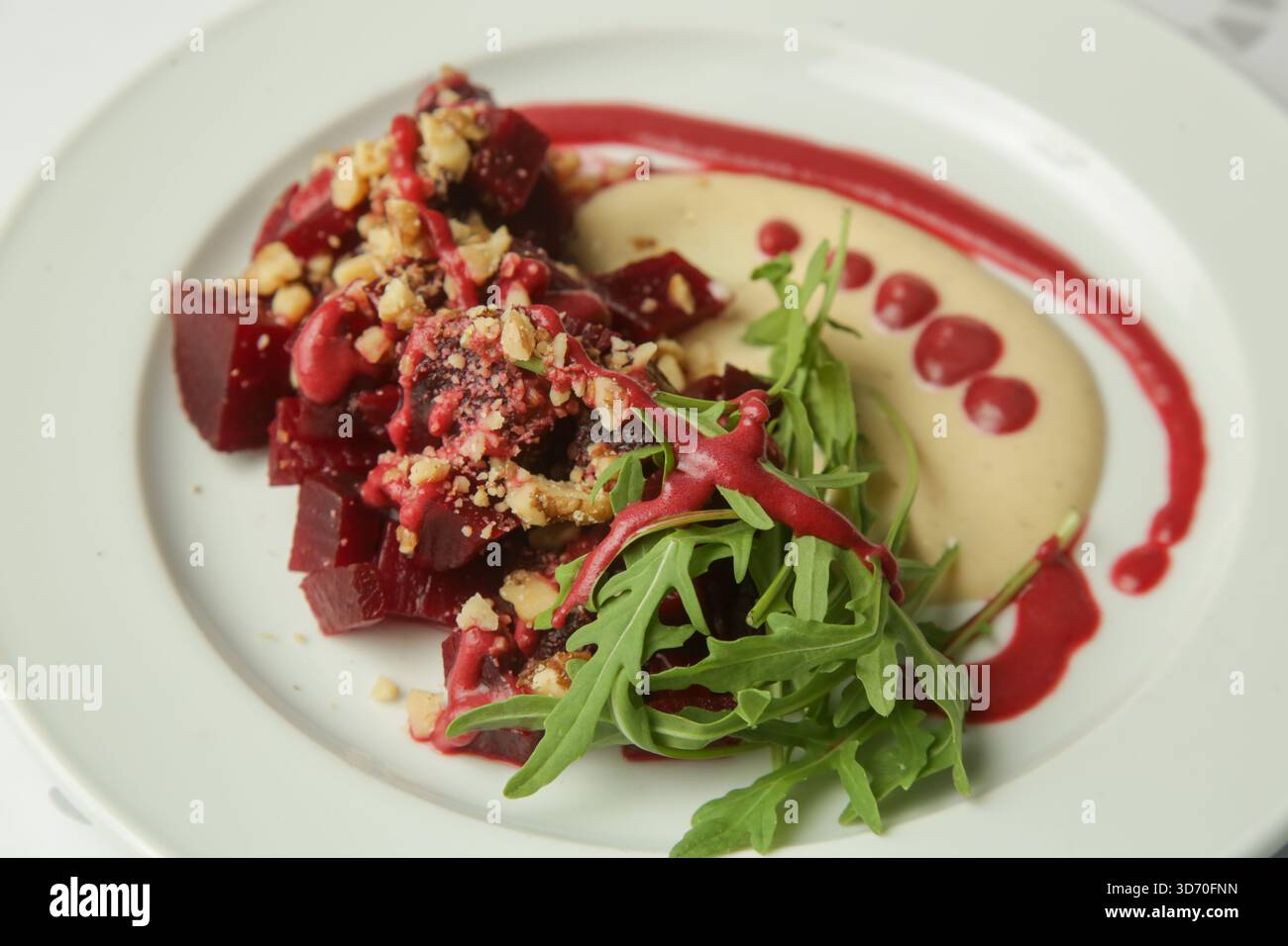 Beetroot salad served with hummus and fresh arugula Stock Photo