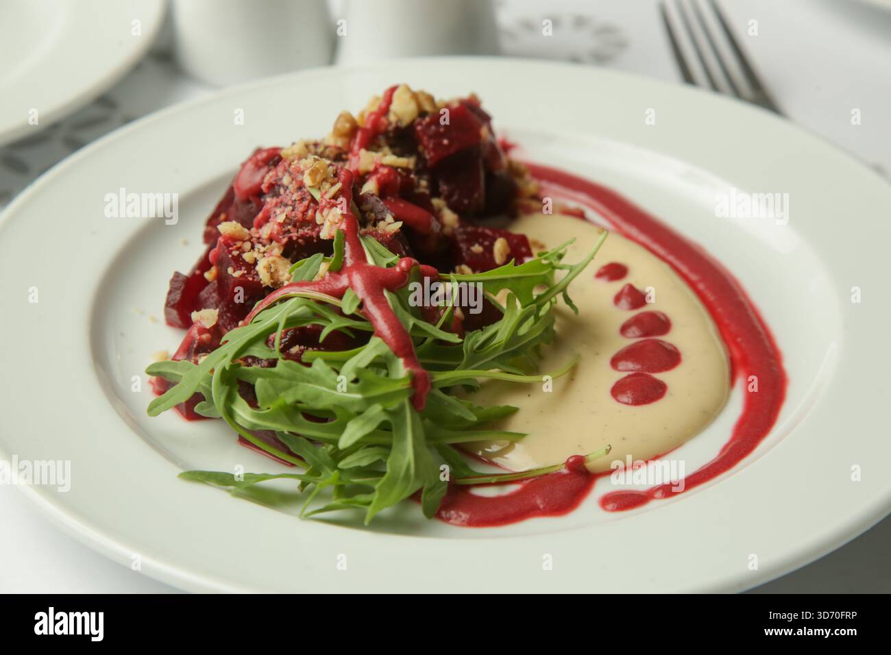 Beetroot salad served with hummus and fresh arugula Stock Photo