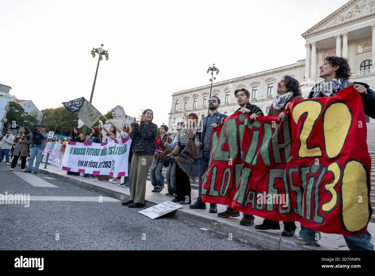 Activists march with banners around the Assembly of the Republic during ...