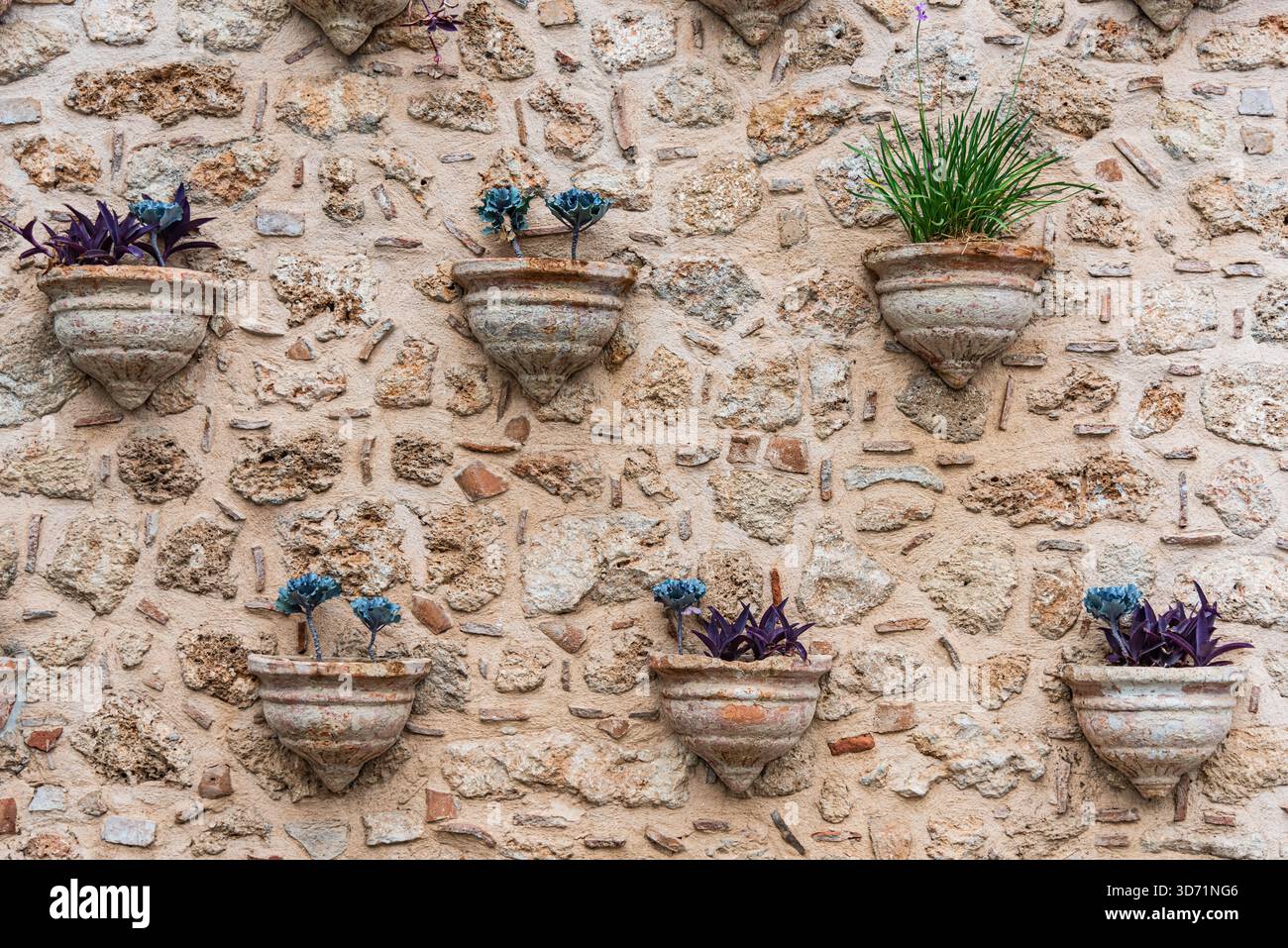 Rustic Stone Wall with Decorative Planters Stock Photo
