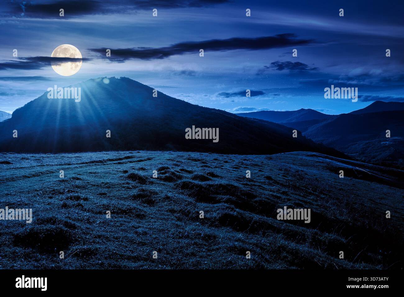 beautiful countryside at night. wonderful summertime landscape in mountains in full moon light. scenic view of grassy field and rolling hills. backgro Stock Photo