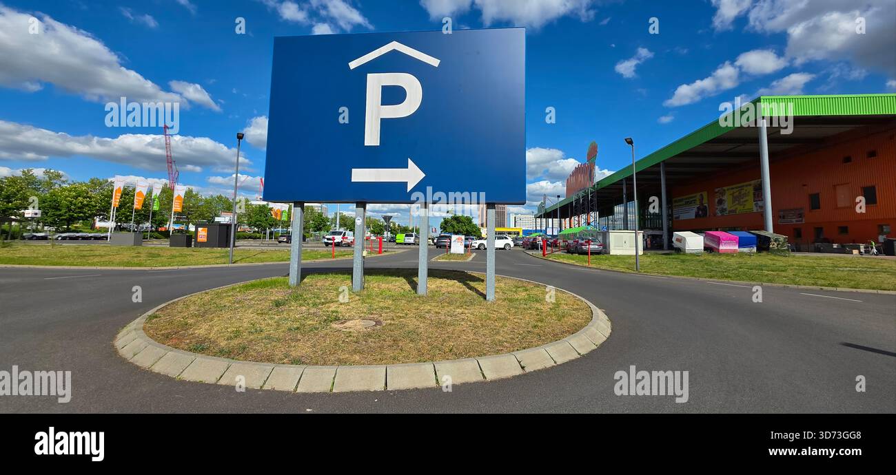Prominent parking sign with directional arrow in a busy commercial area. - Smartphone Captured Stock Image