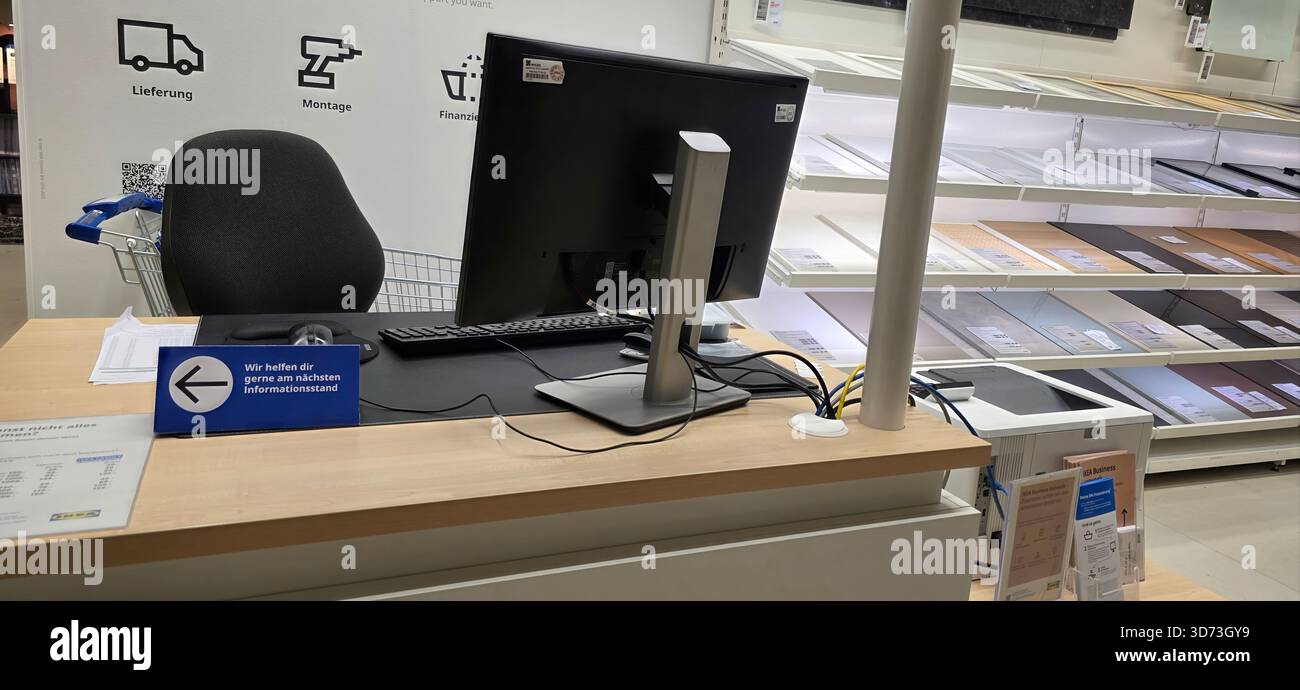 Berlin, Germany - May 05, 2025: Modern checkout counter features computer setup and organized display area for customers. - Smartphone Captured Stock Image
