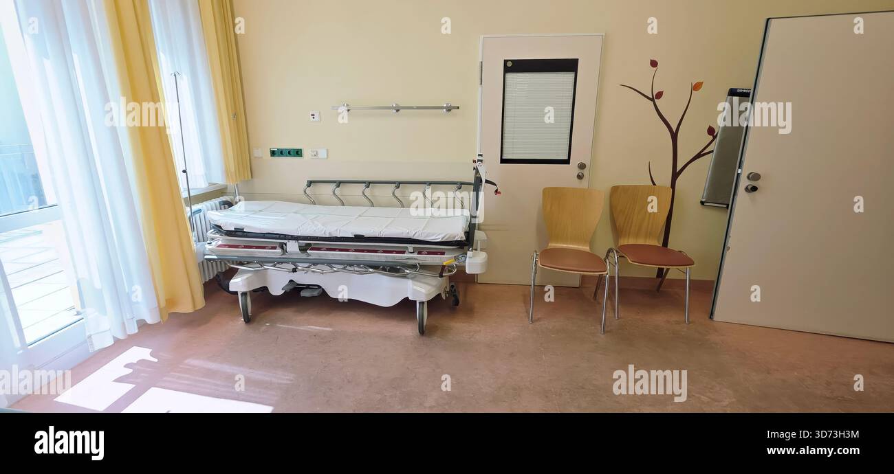 Berlin, Germany - June 16, 2025: Hospital room features an empty bed and chairs, bright natural light fills the space. - Smartphone Captured Stock Image