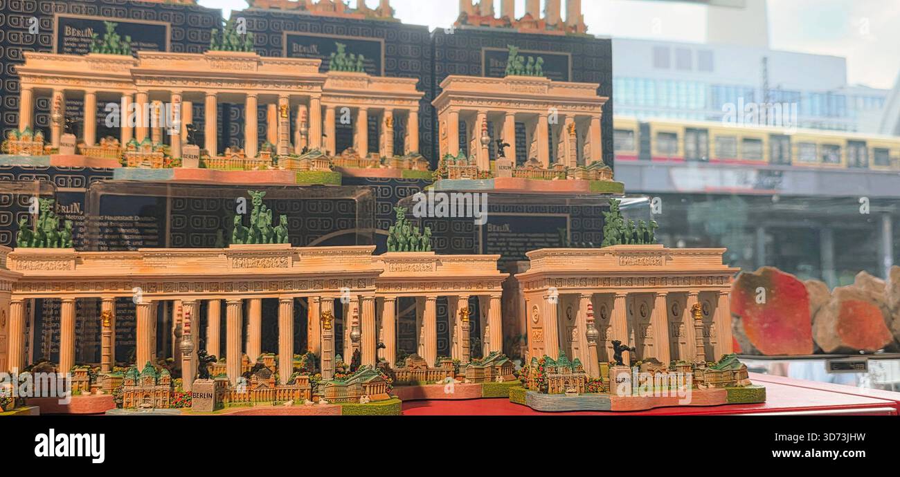 Berlin, Germany - August 27, 2025: . Miniature models of Brandenburg Gate are showcased in shop window with urban scenery behind - Smartphone Captured Stock Image
