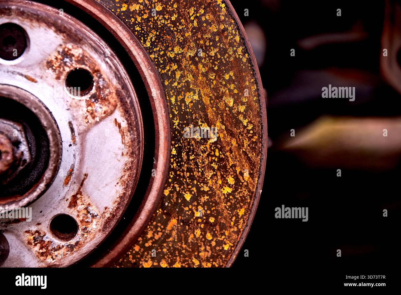 A close-up of a car brake disc shows a heavy layer of rust and ...
