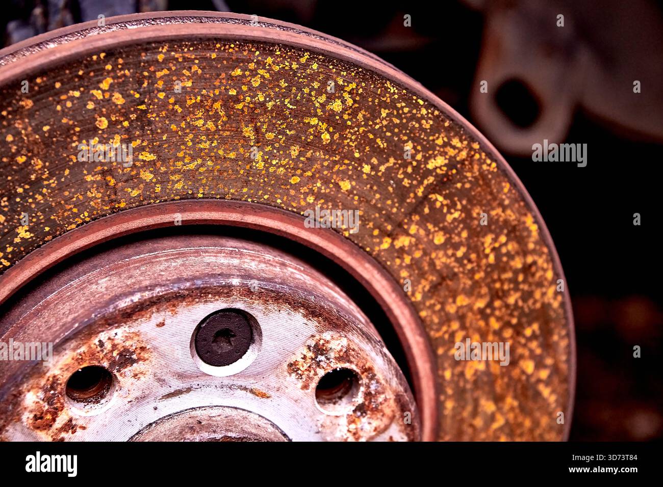 A close-up of a car brake disc shows a heavy layer of rust and ...
