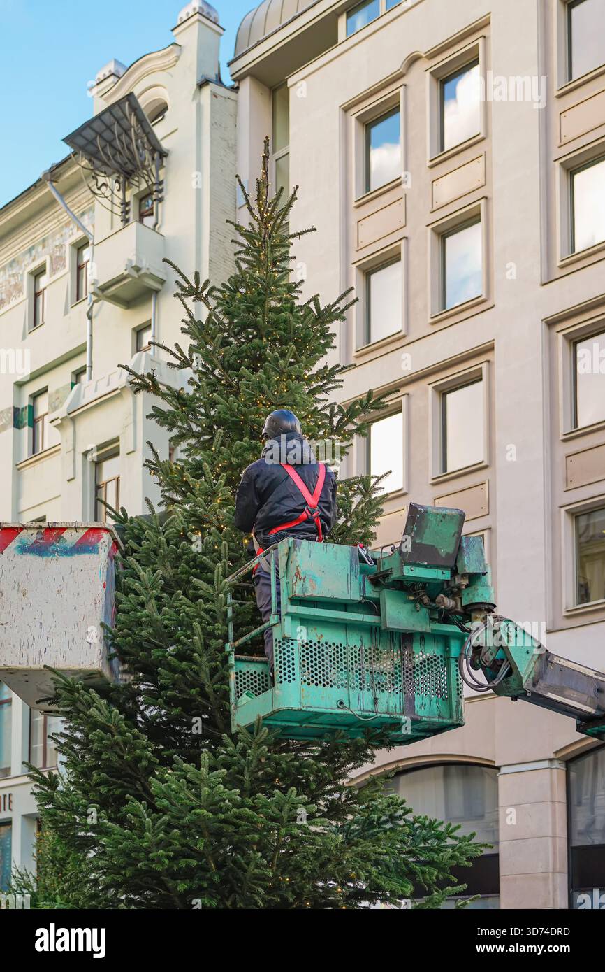 Christmas tree installation, worker on truck crane installing ...