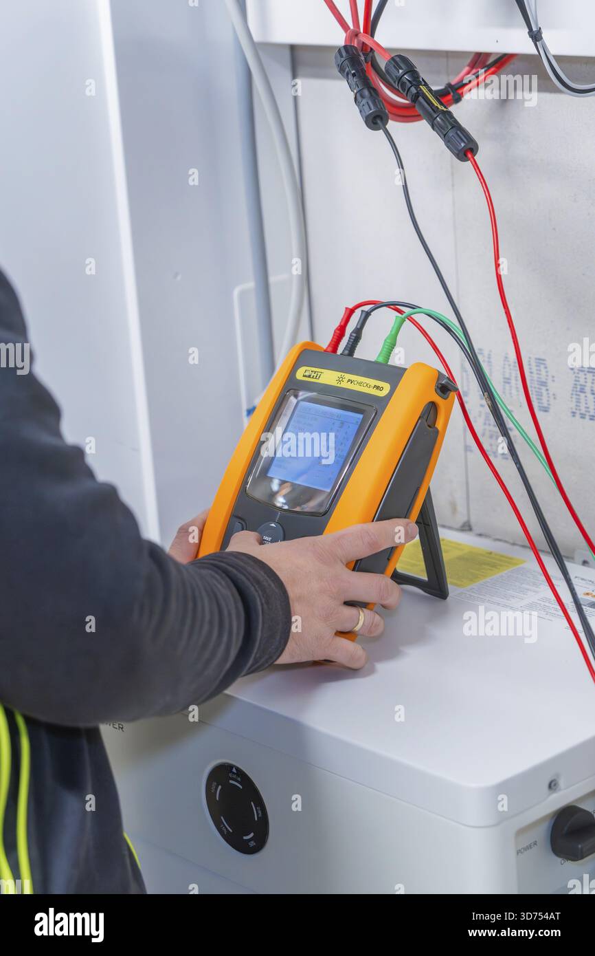 Technician uses measurement device to install solar system Stock Photo