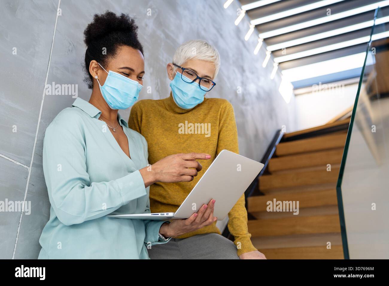 Busy business people, programmers software developer engineer working on computer in office in masks Stock Photo