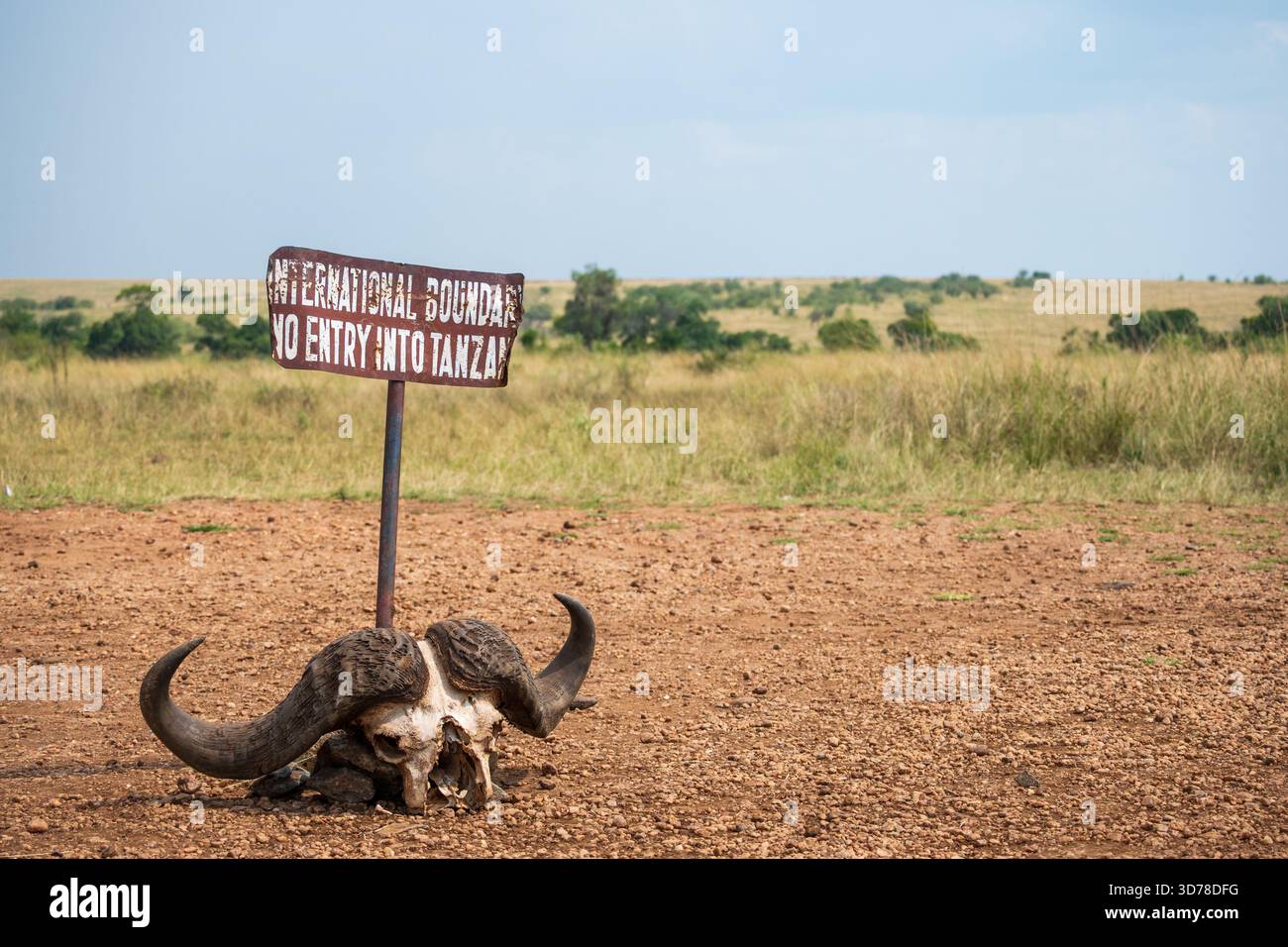 International Border, No entry to Tanzania. Sign on Kenyan Tanzanian border with buffalo skull warning travellers not to cross Stock Photo