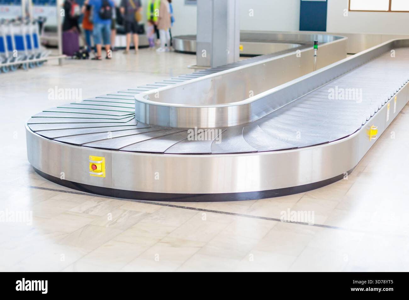 Empty baggage claim area with a curved conveyor belt inside an airport ...