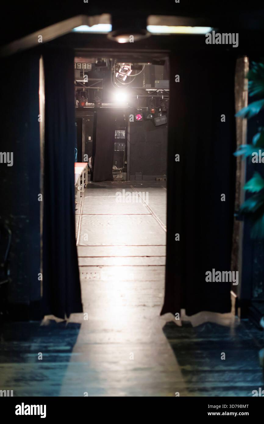 backstage view of bright stage through curtains in a performance venue during a show setup Stock Photo