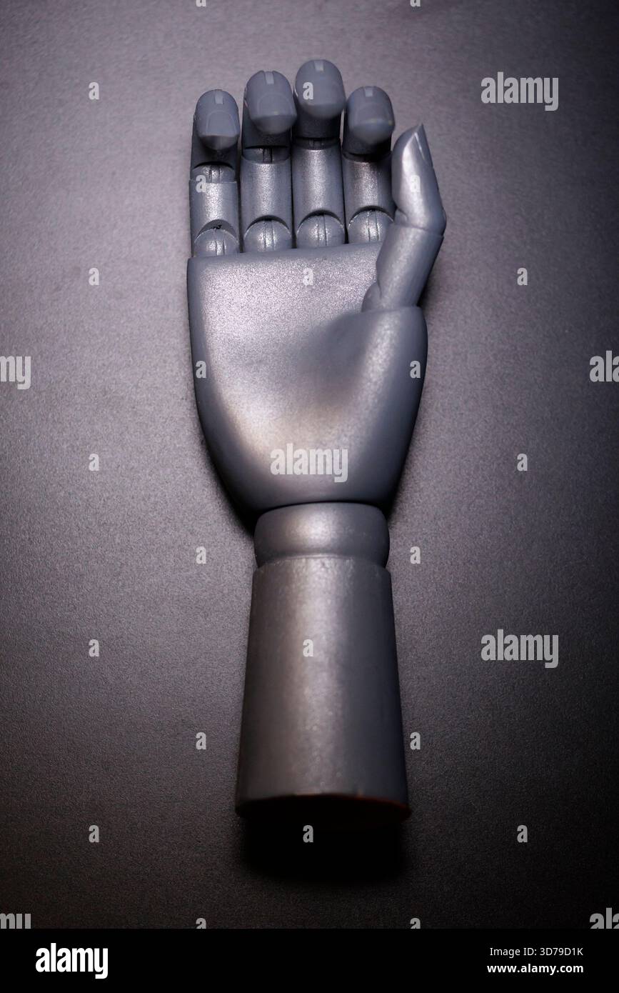 robotic hand displayed on black surface Stock Photo