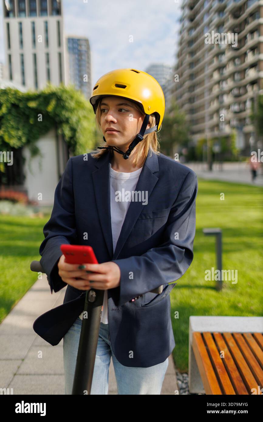 young woman using navigation app while riding an electric scooter Stock Photo