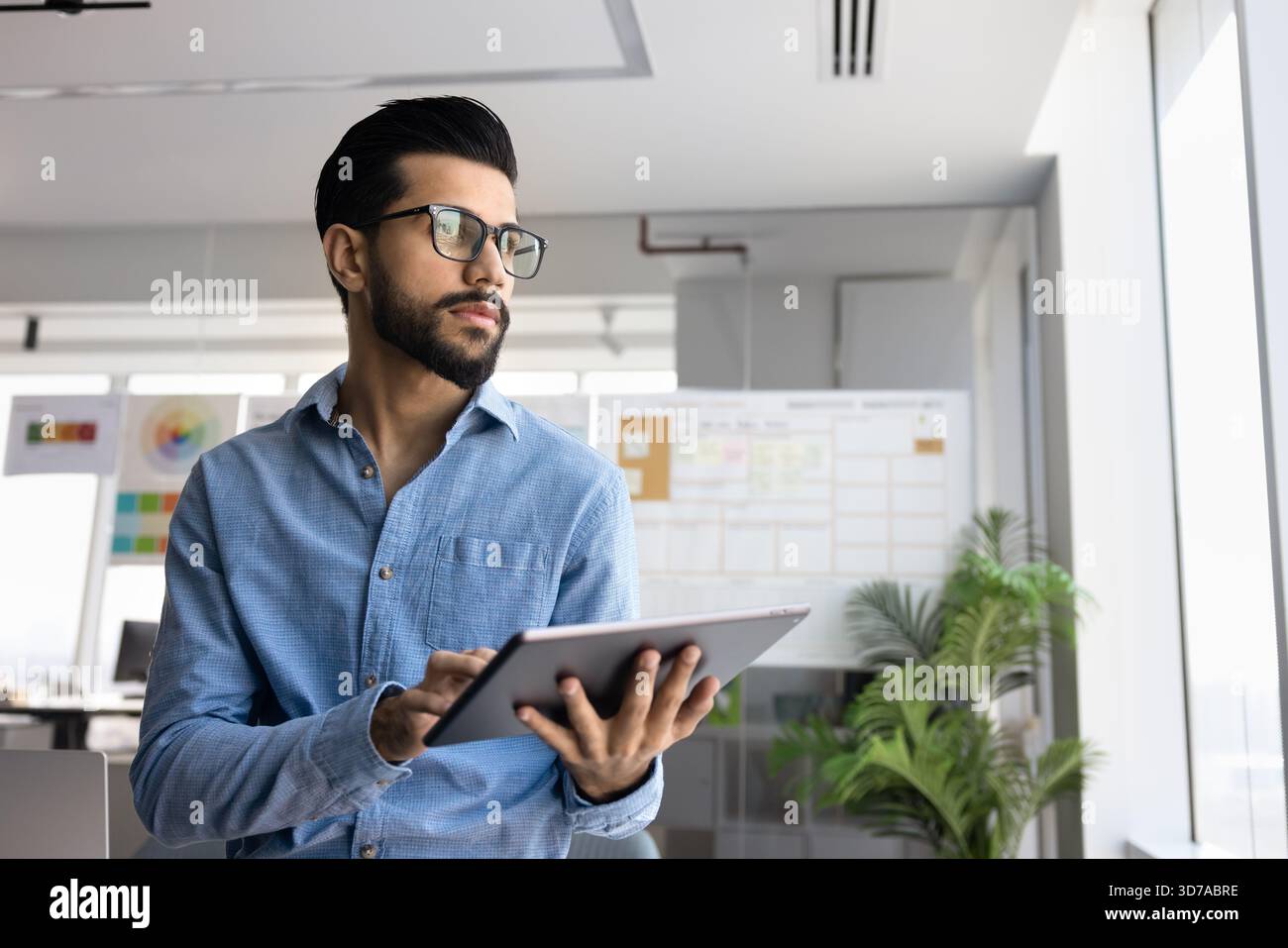 Thoughtful professional man managing online business process on tablet Stock Photo