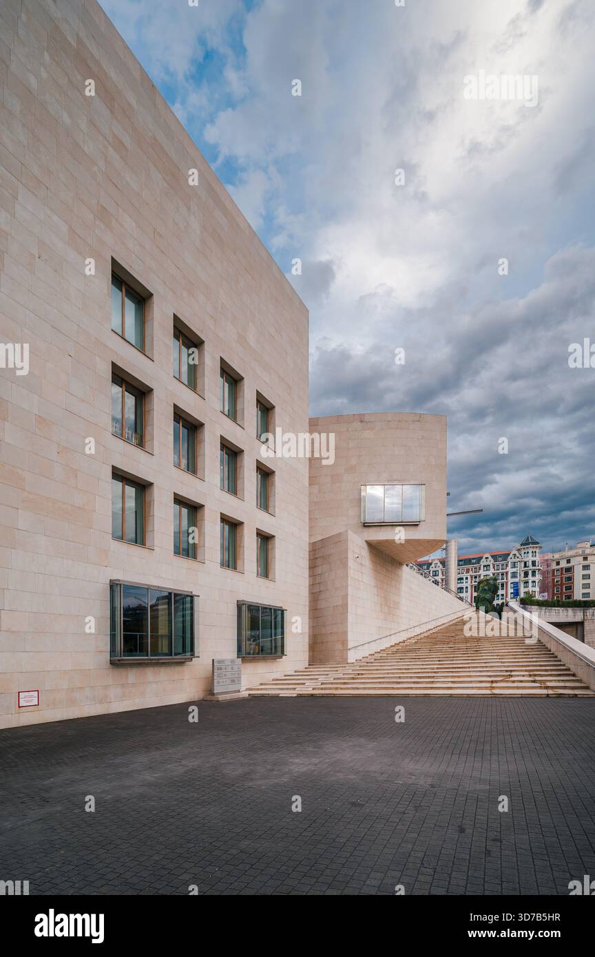 Stone textured facade and brutalist concrete stairs defining a modern ...