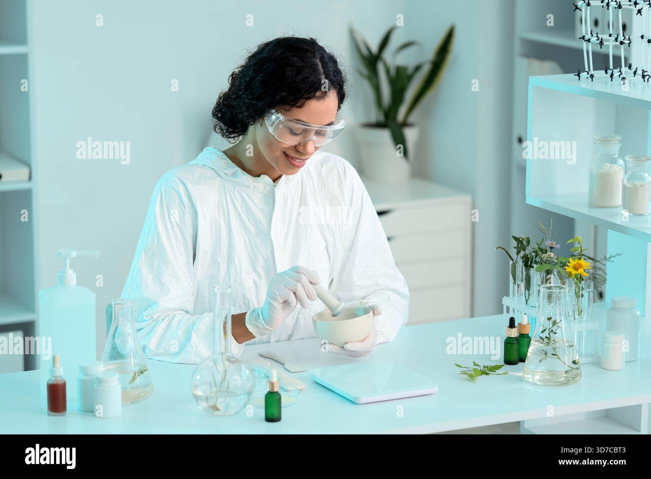 Pretty young African-American female biologist with mortar and pestle ...