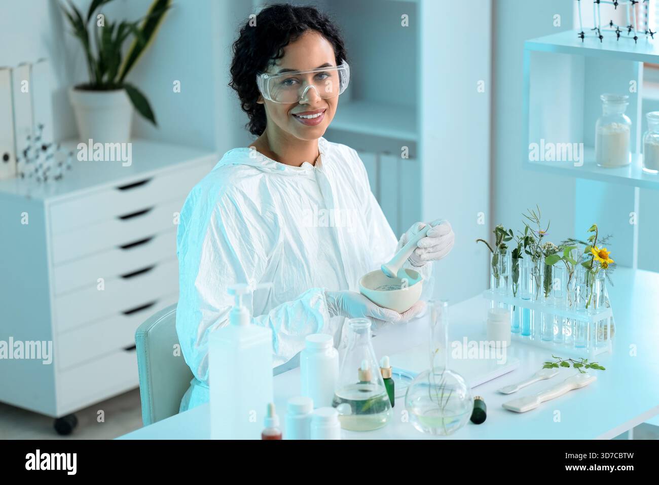 Pretty young African-American female biologist with mortar and pestle ...