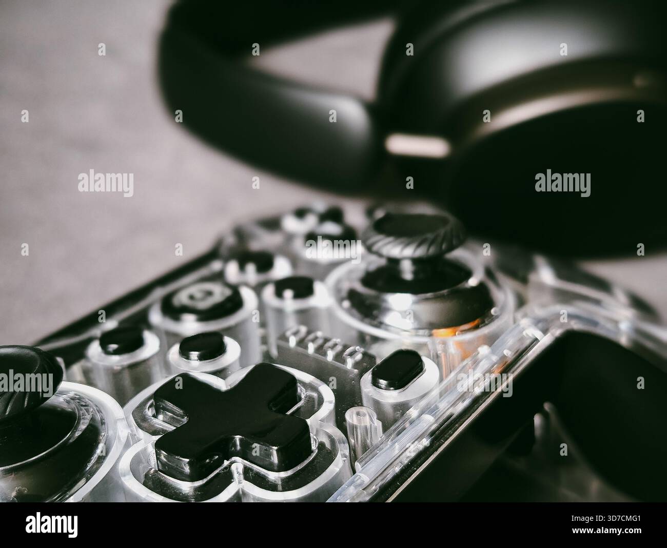 transparent game controller and wireless headphones gaming setup technology Stock Photo