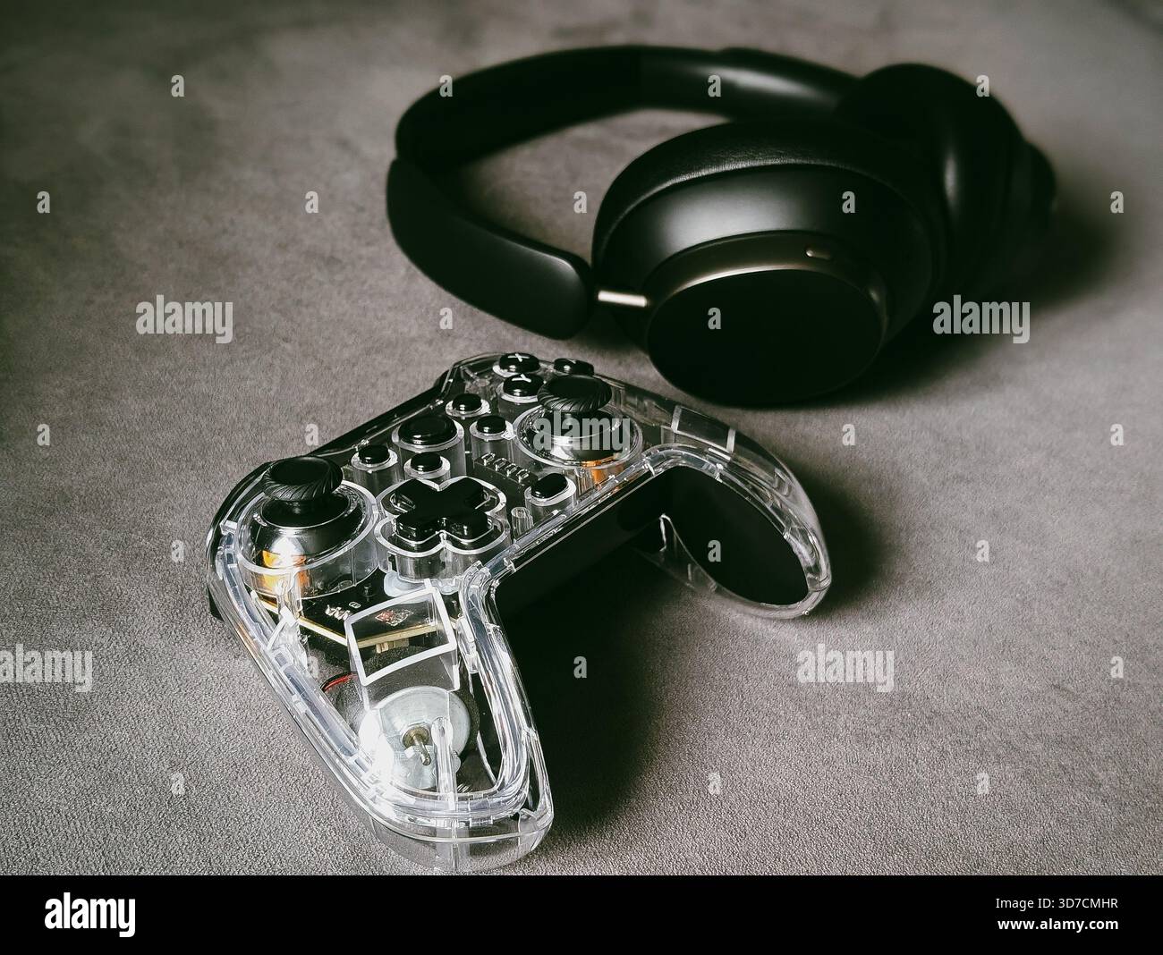 transparent game controller and wireless headphones gaming setup technology Stock Photo