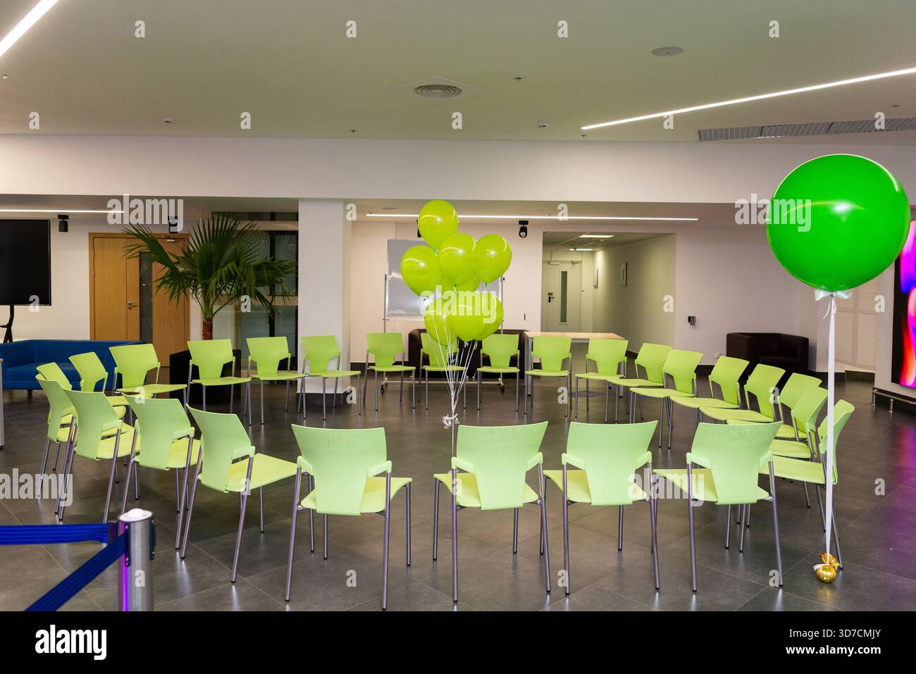A modern conference room set up with vibrant green chairs arranged in a ...