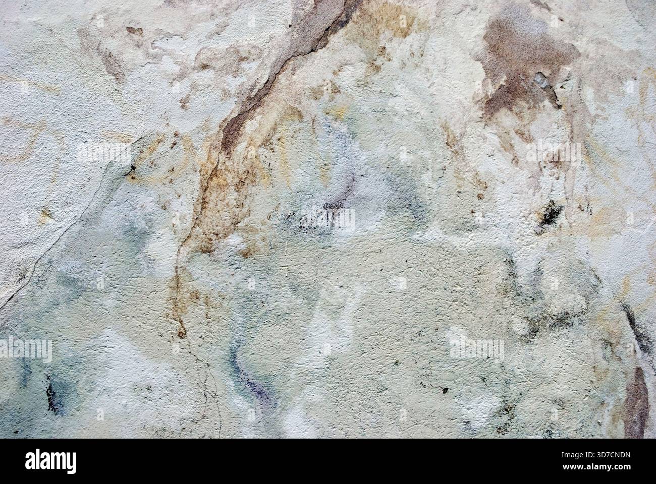 Decayed wall surface with cracks, stains, and weathered textures creating an abstract pattern Stock Photo
