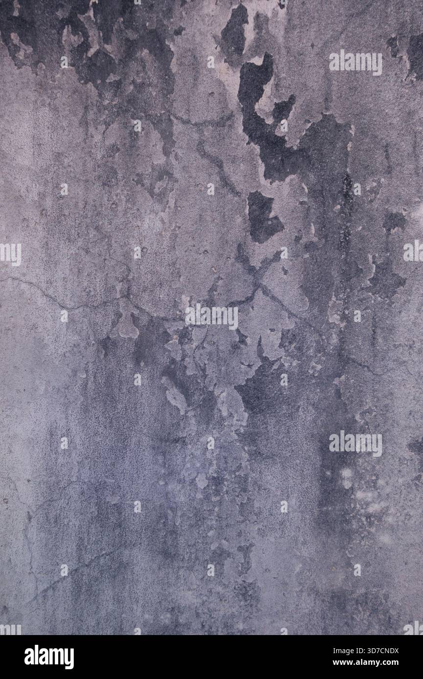 Decayed wall surface with cracks, stains, and weathered textures creating an abstract pattern Stock Photo