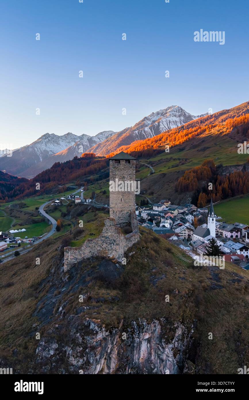 Autumnal sunset on the town and medieval tower of Ardez at sunset. Scuol, Canton of Graubünden, district of Inn, lower Engadine, Switzerland, Europe. Stock Photo