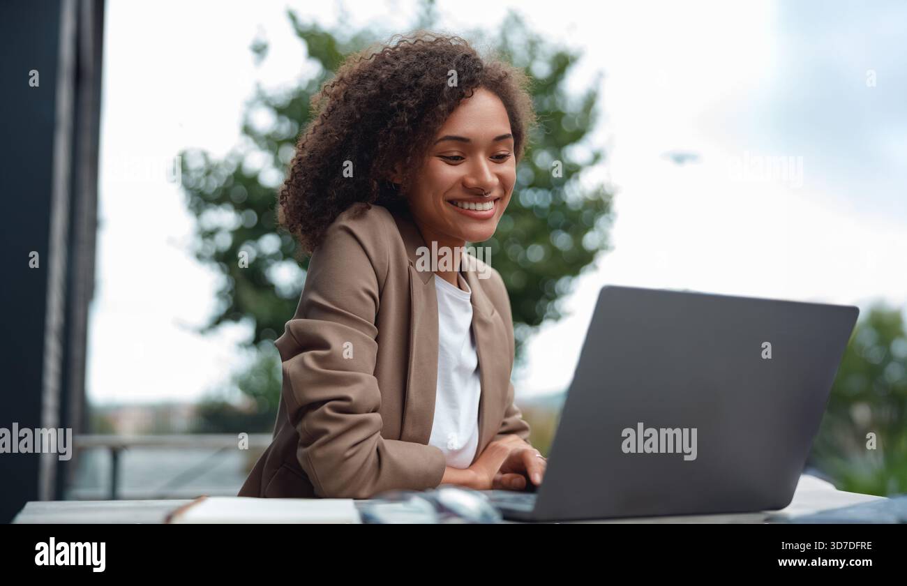 coder working outside, software engineer diligently coding outside near glass skyscraper with coffee Stock Photo