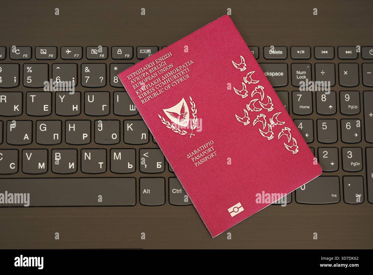 Kyprus passport lies on black laptop keyboard buttons background close up. Technologies and control in Europe concept Stock Photo