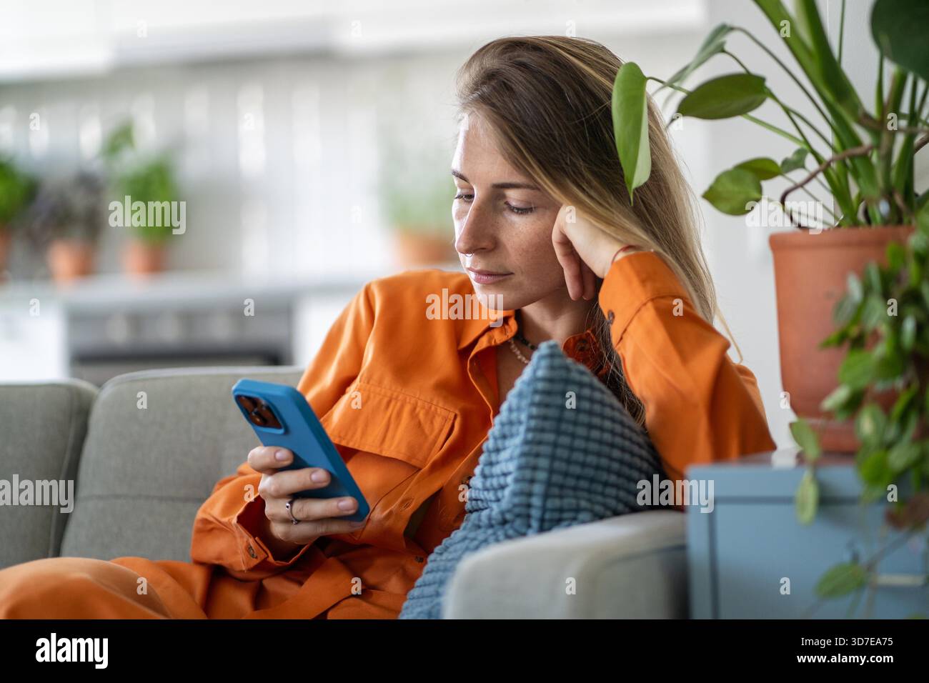 Calm middle-aged woman scrolling web feed on smartphone, chatting and ...