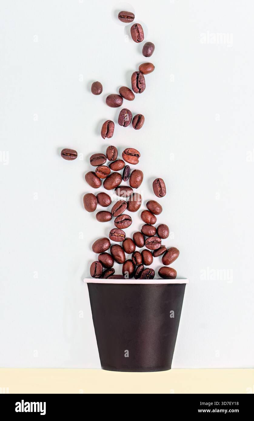 Coffee beans falling in to a paper cup Stock Photo