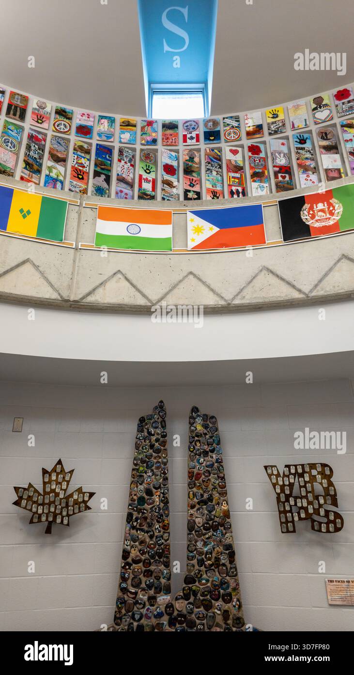 Multicultural school atrium with skylight, flags, and symbolic art honoring diversity and remembrance. - Smartphone Captured Stock Image