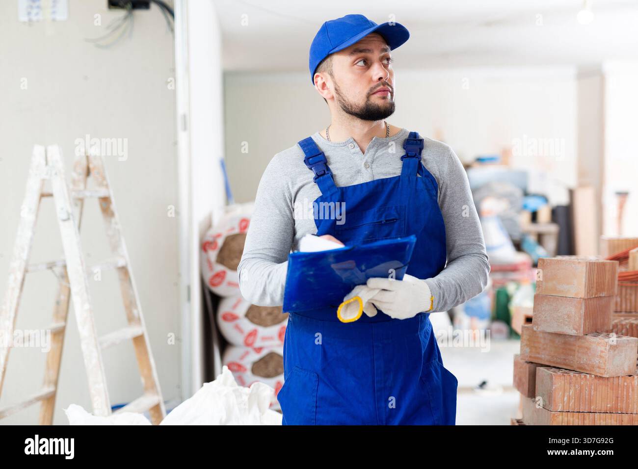 Foreman reading papers on indoor construction site Stock Photo