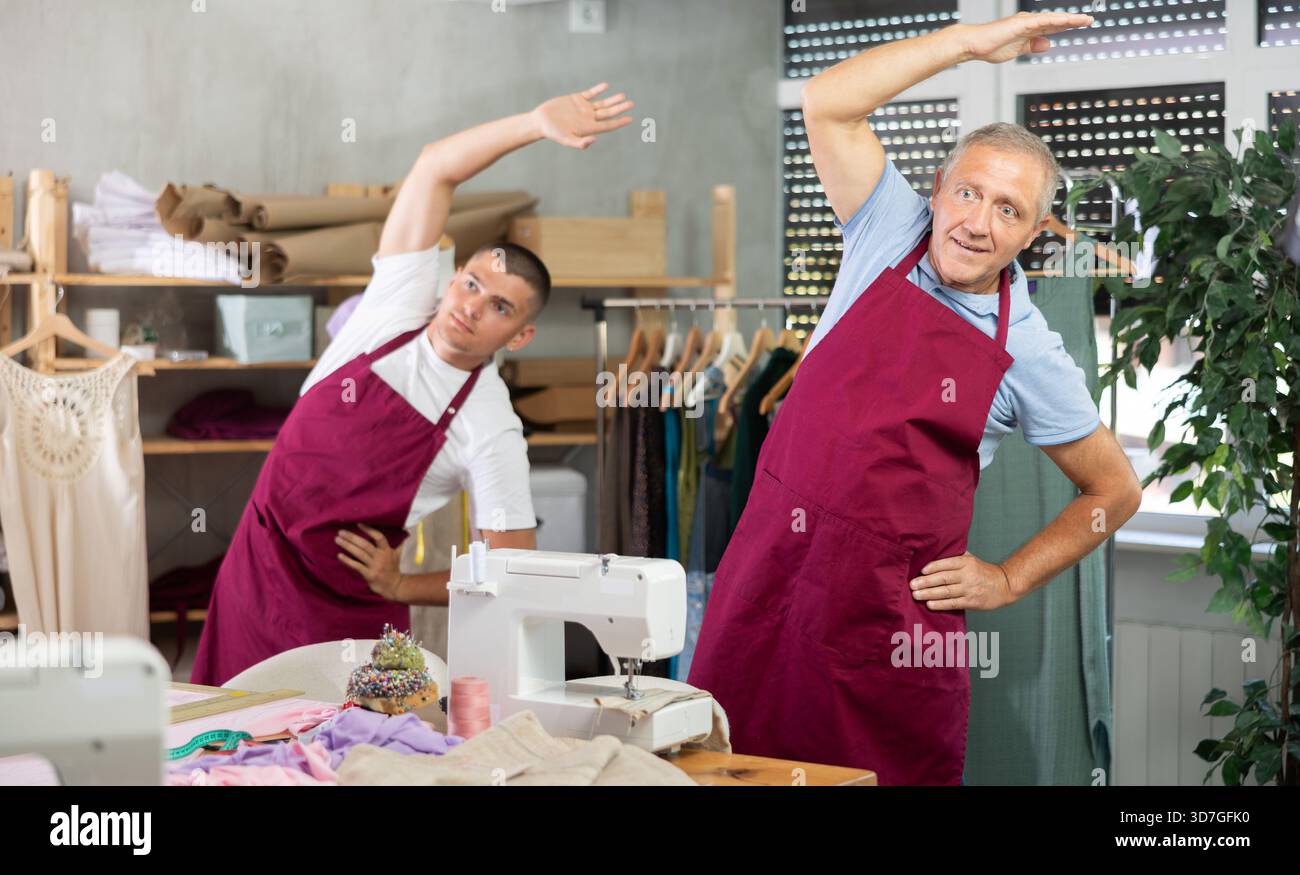 Male tailors doing a warm-up at work Stock Photo