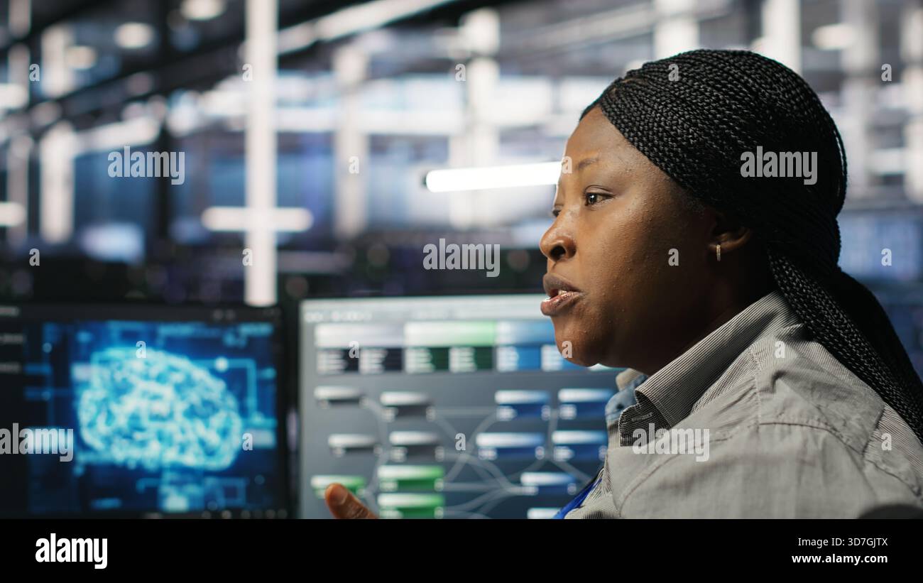 Data center engineering team deploying AI solutions optimizing gear. Server hub teamworking colleagues working together, using artificial intelligence to minimize systems downtime, camera B Stock Photo