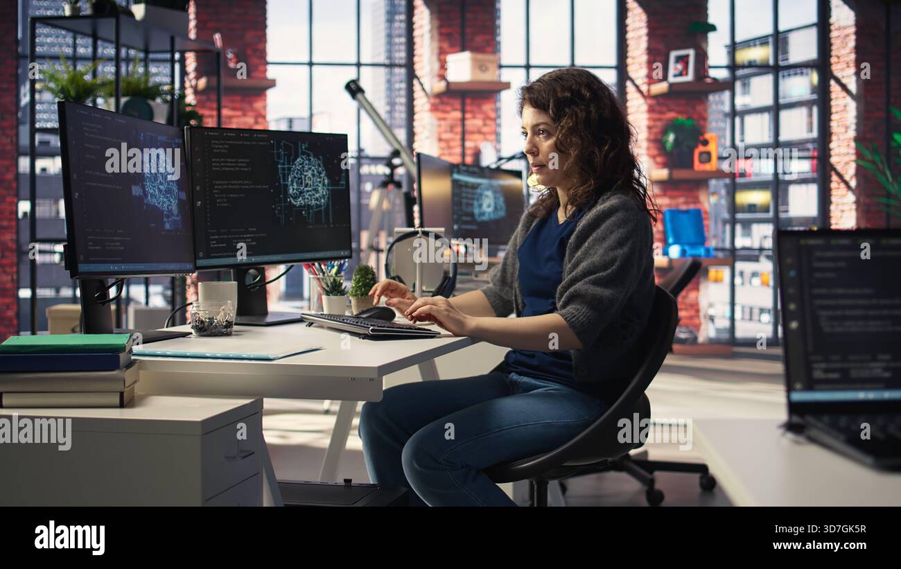 IT technician writing code and debugging on artificial intelligence neural networks computerized brain model. Female tech support doing checkup on AI systems, cloud computing. Camera A. Stock Photo