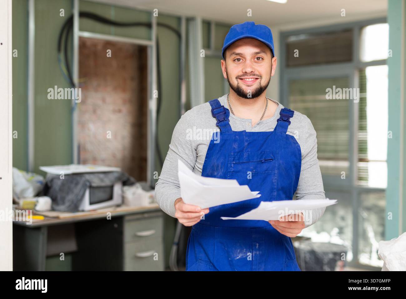 Foreman reading papers on indoor construction site Stock Photo
