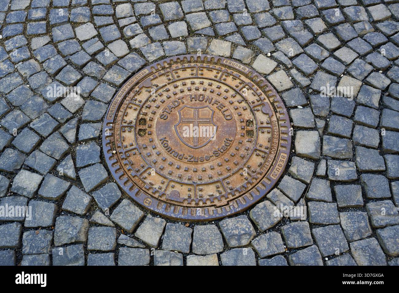 Round metal manhole cover on paved ground with interesting structure ...