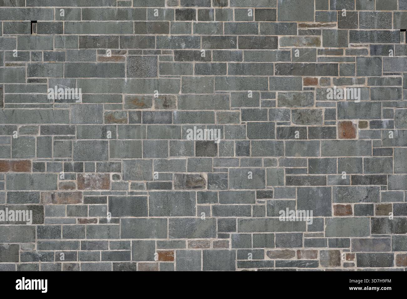 Background of grey rectangular stone wall. Random size stone wall. Stock Photo