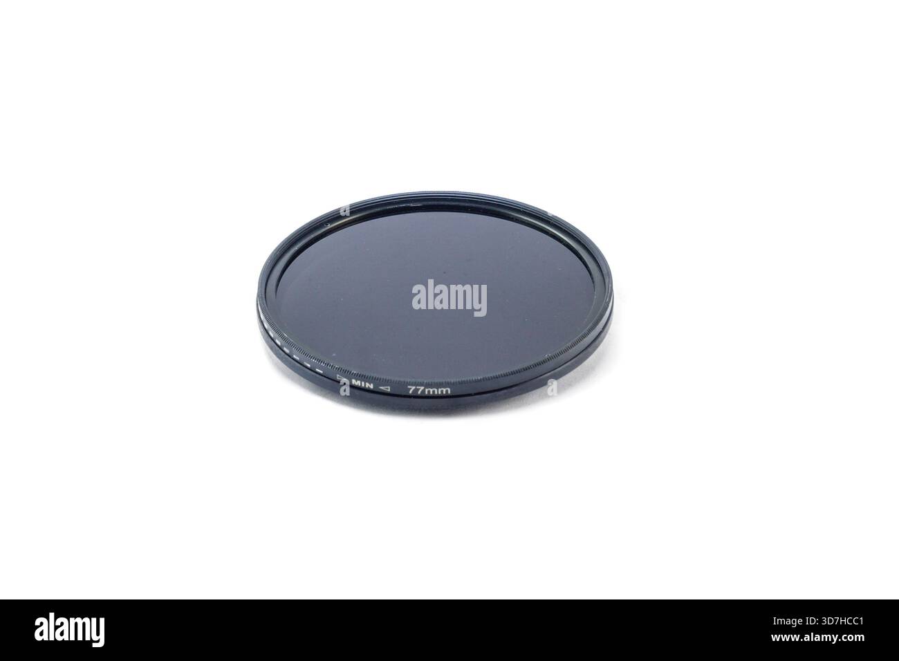 A dark, black-rimmed 77mm circular polarizing (CPL) camera filter, isolated on a clean white studio background. Stock Photo
