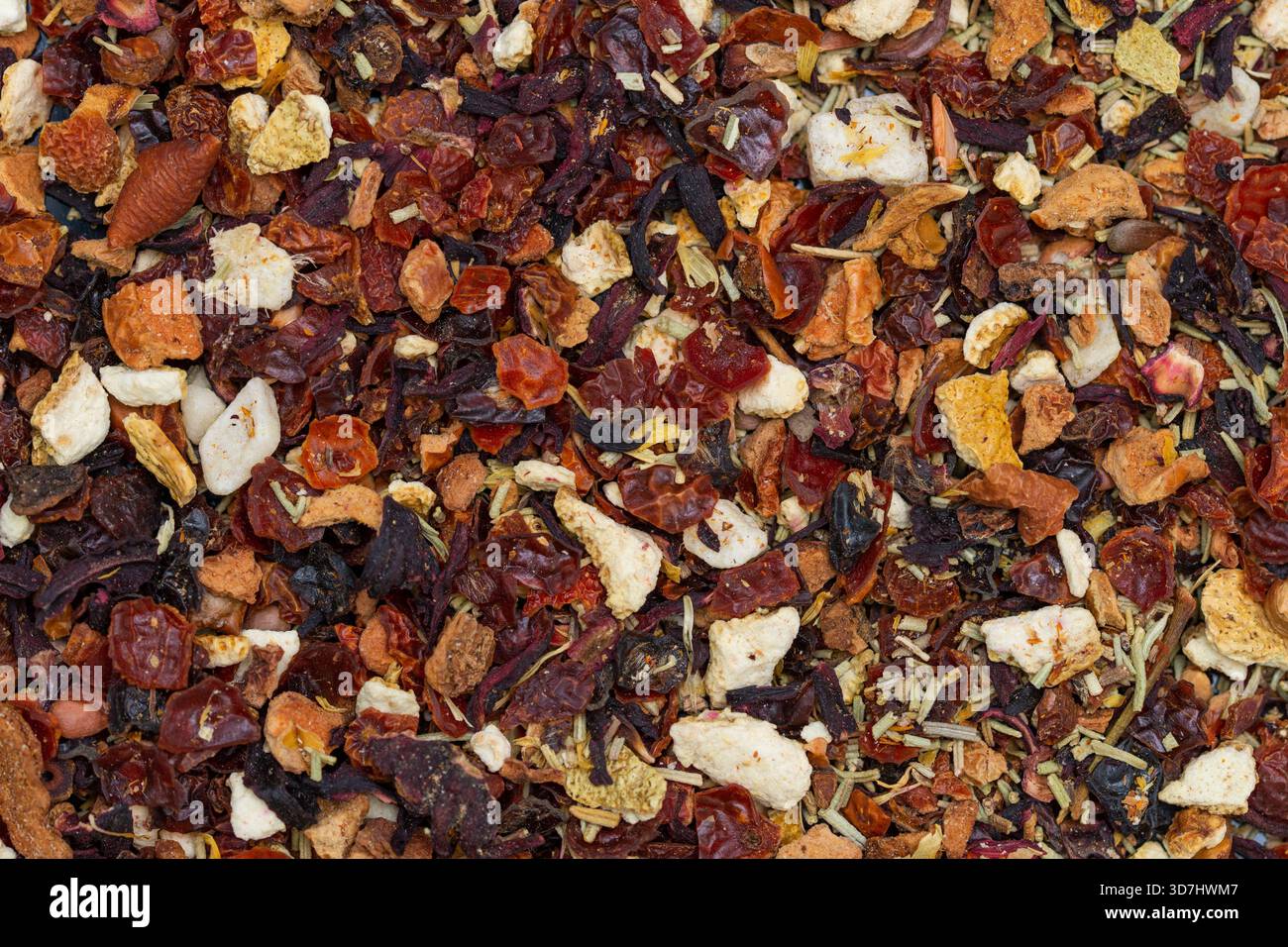 a mixture of dried fruits, herbs, and spices, commonly used for fruit tea infusions, including apple pieces, hibiscus, rose hips, and other berries. Stock Photo
