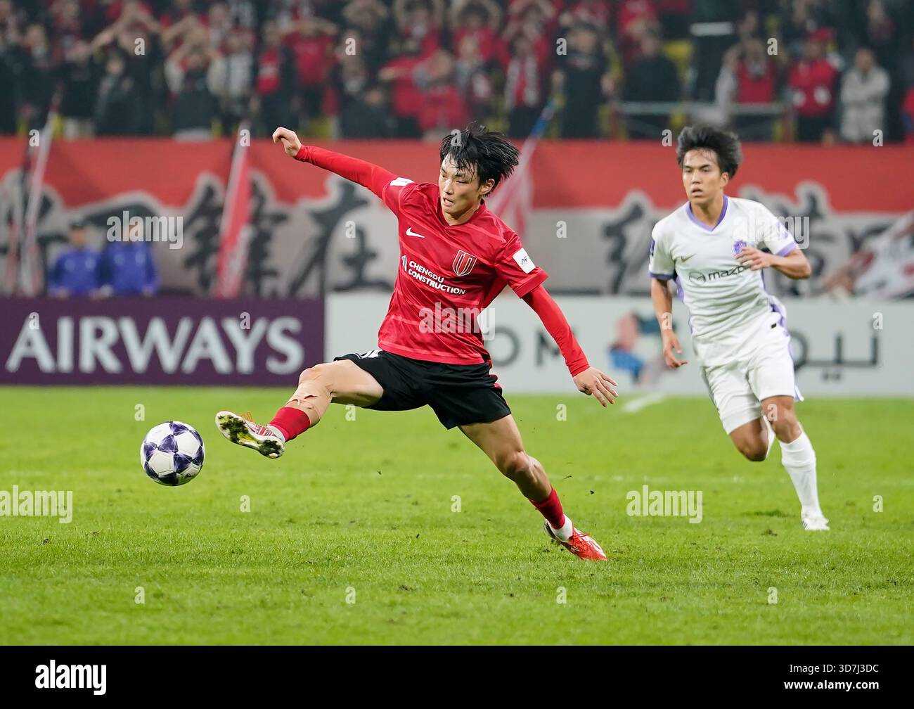 Yang Mingyang (L) of Chengdu Rongcheng competes during the group F ...