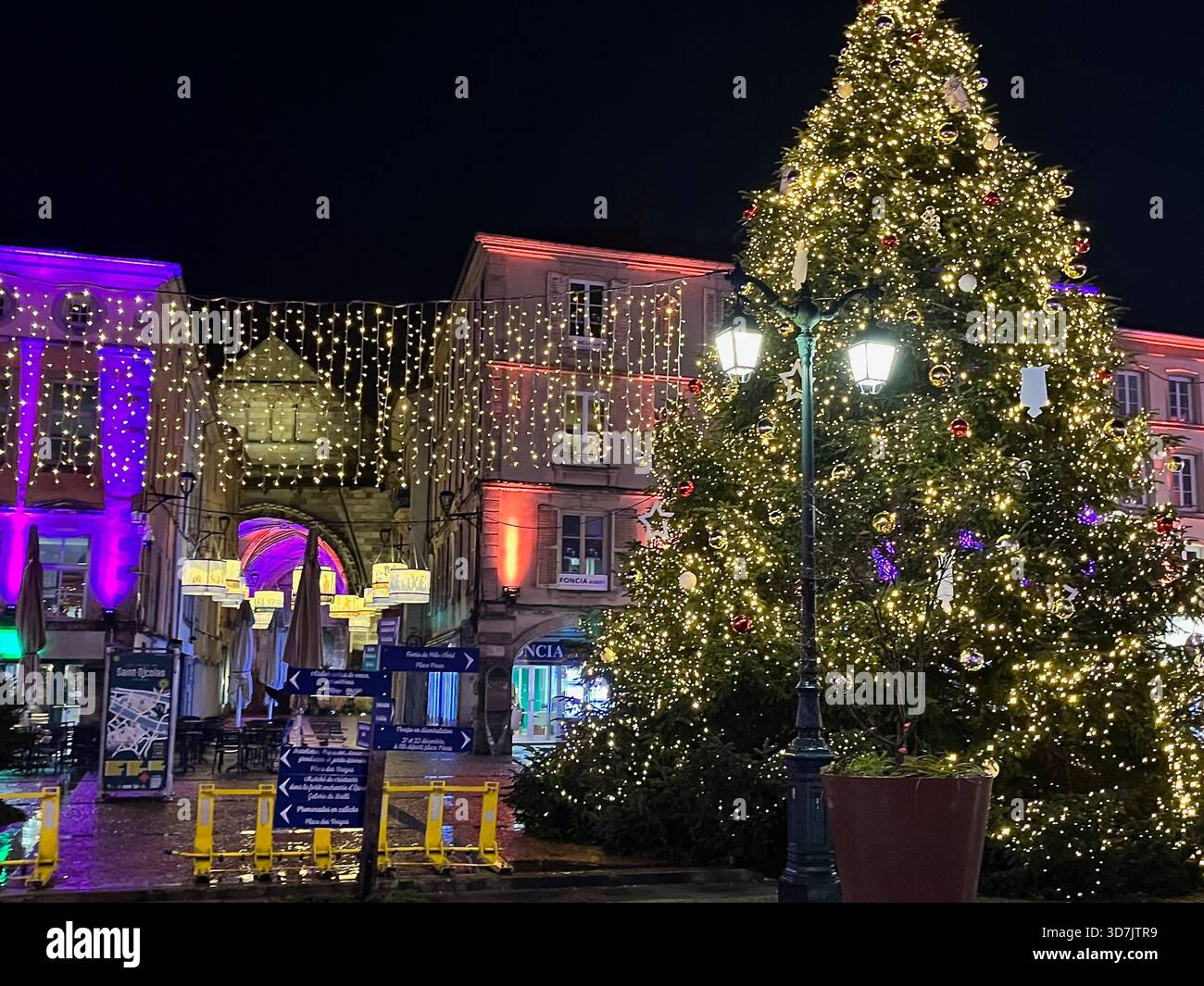 Épinal, France – 2 December 2024: A glowing holiday passage with hanging lights and illuminated arches creates a festive nighttime atmosphere - Smartphone Captured Stock Image