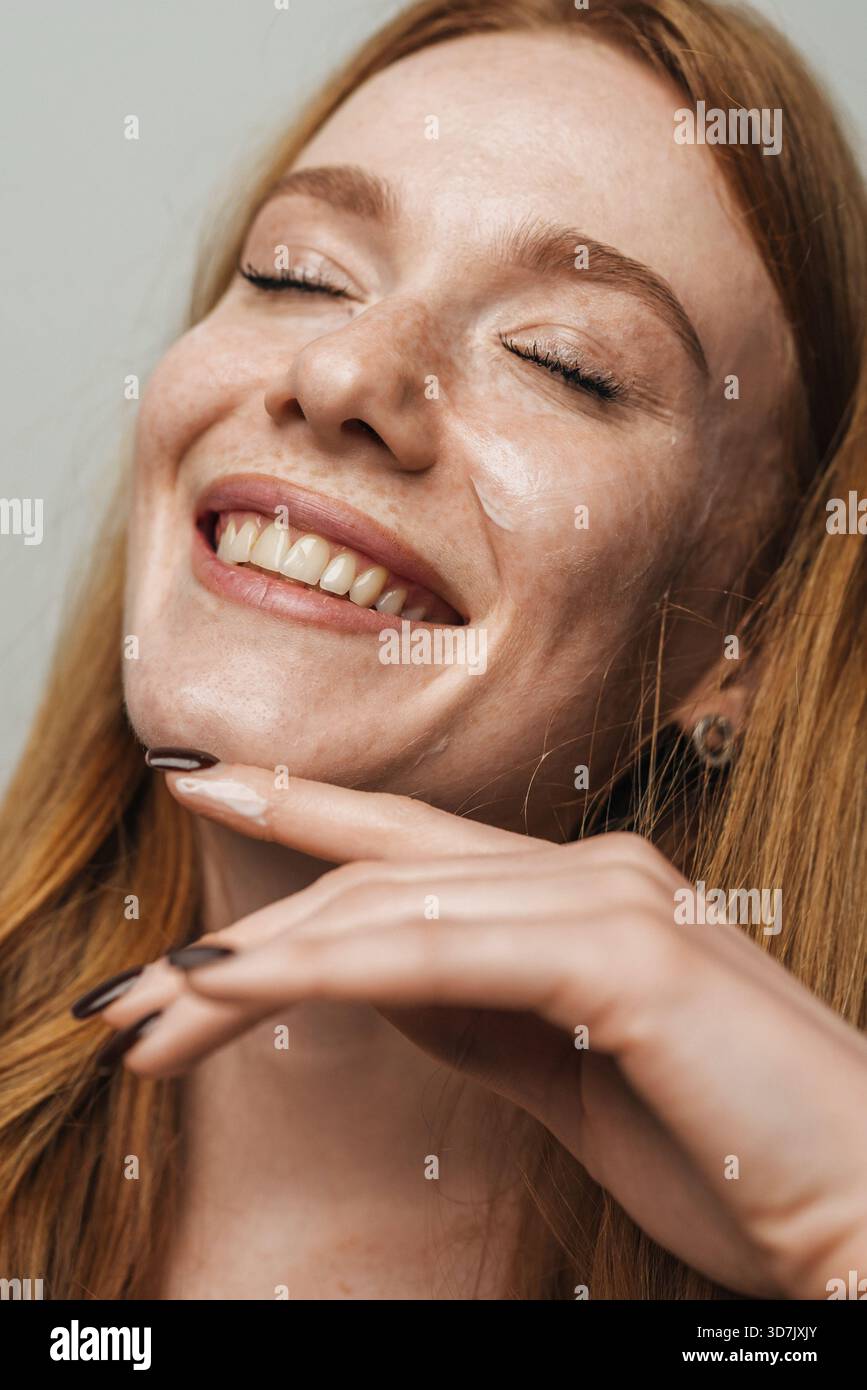 woman with fiery hair and joyful glow, energized redhead shows off glowing skin and cheerful demeanor Stock Photo