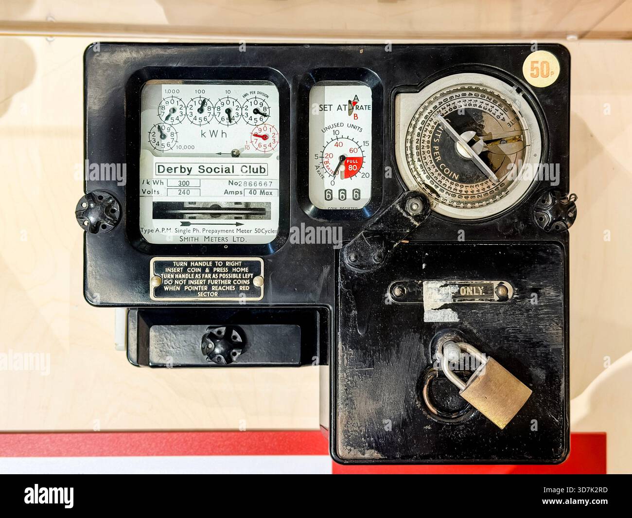Close-up of an old British prepay coin-operated electricity meter with dials and instructions visible on the front panel - Smartphone Captured Stock Image
