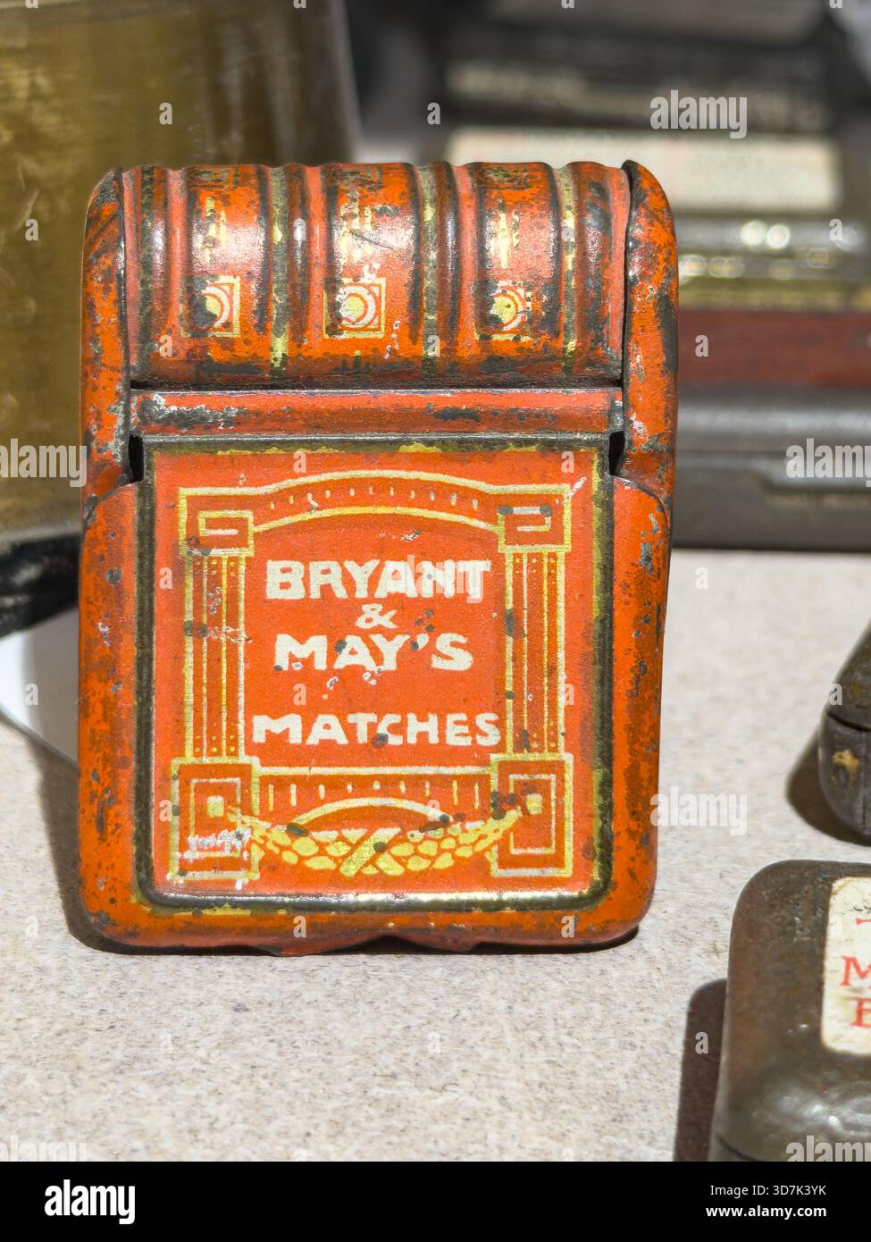 Vintage red metal match holder for Bryant and May's matches with aged painted surface and retro typography design - Smartphone Captured Stock Image