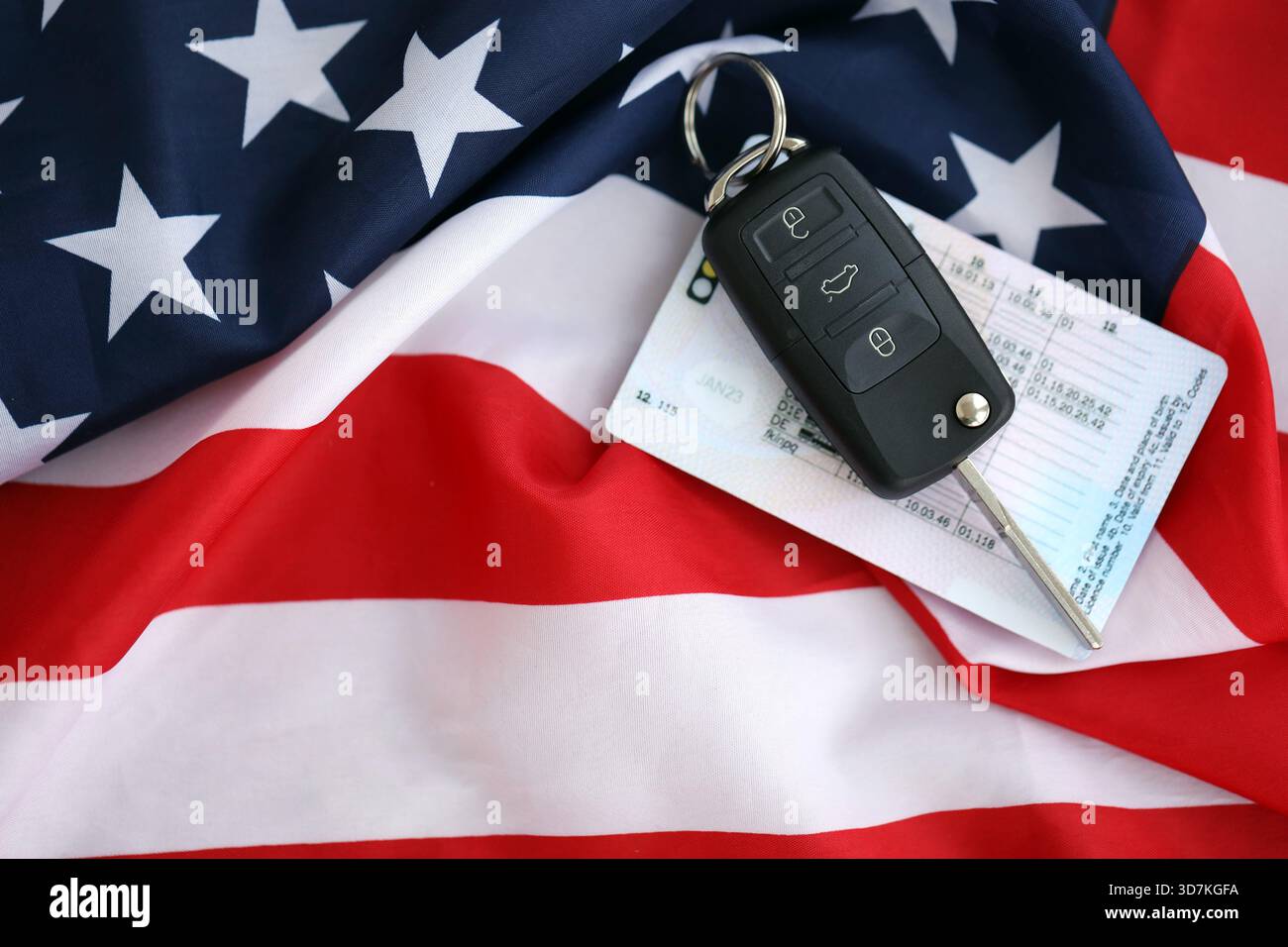 Ignition keys with remote control buttons and driver license card on ...