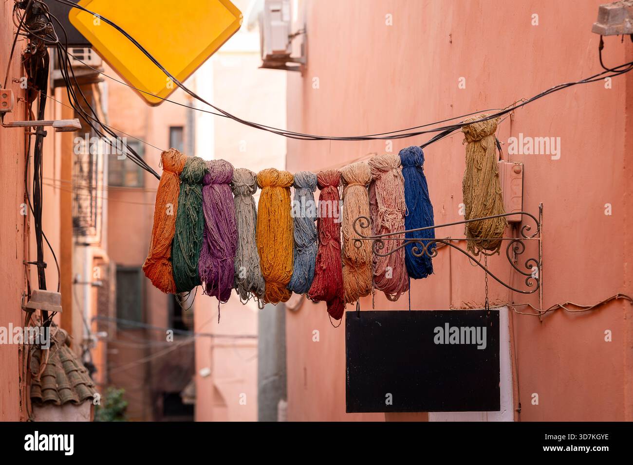 Dyed wool hanging in the souks of Marrakesh, Morrocco. Small street in Marrakech's medina (old town). Naturally dyed wool yarn. Stock Photo